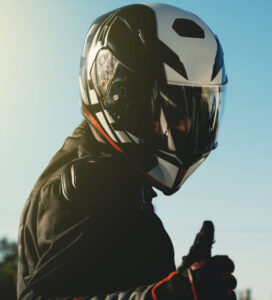 man wearing motorcycle helmet giving thumbs up